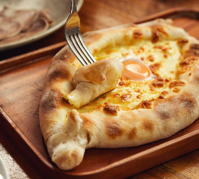 Adjarian Khachapuri (món ăn truyền thống của Gruzia làm từ bột và nhiều loại phô mai khác nhau với trứng)